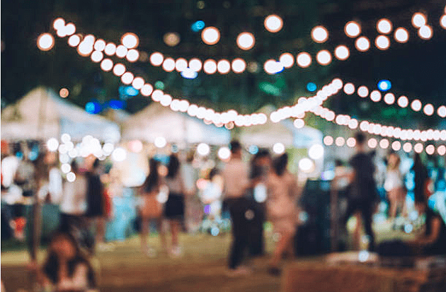 Professional evening event setup in Myrtle Beach featuring high-peak frame tents and elegant bistro string lighting by Coastal Party Rentals.