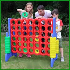 Children playing with a Giant Connect 4 yard game rental at an outdoor party in Murrells Inlet.